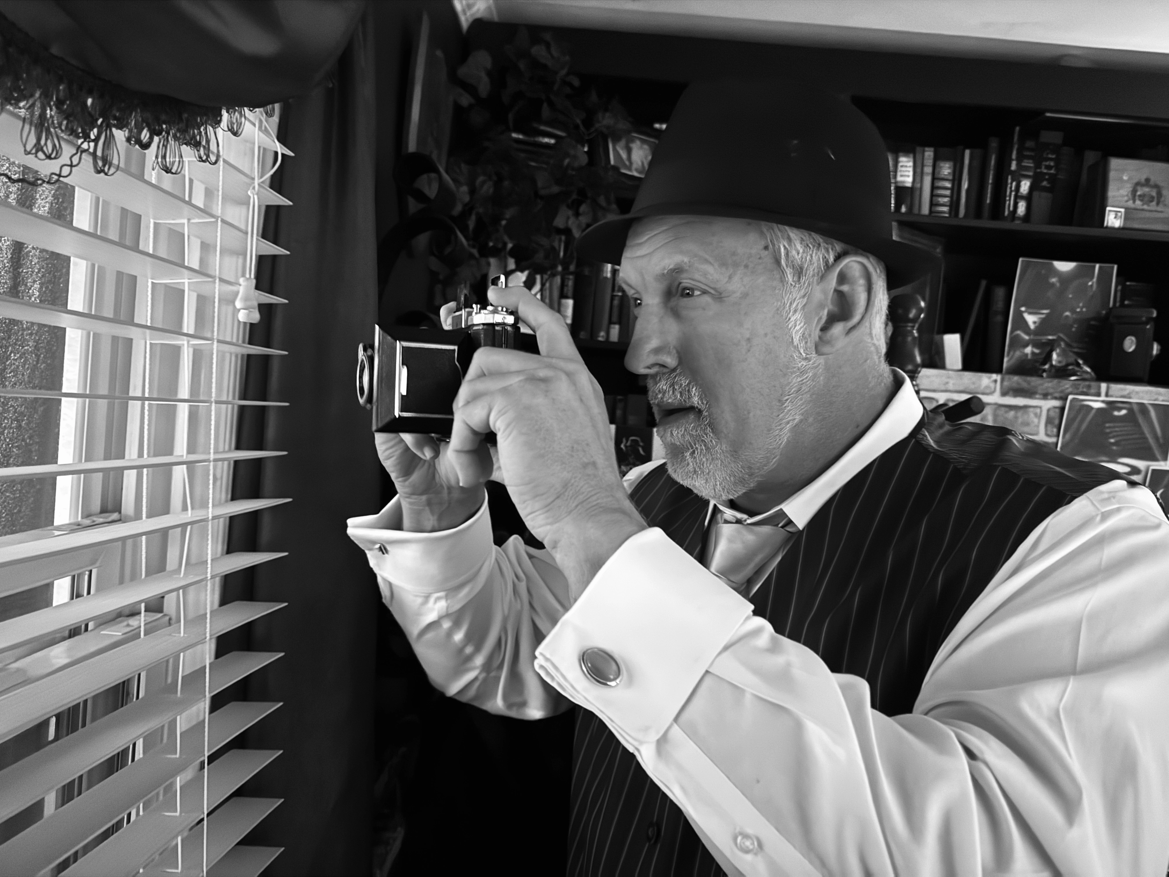 Detective Watson with camera through venetian blinds — Noir Cigar™ creator Scott Watson